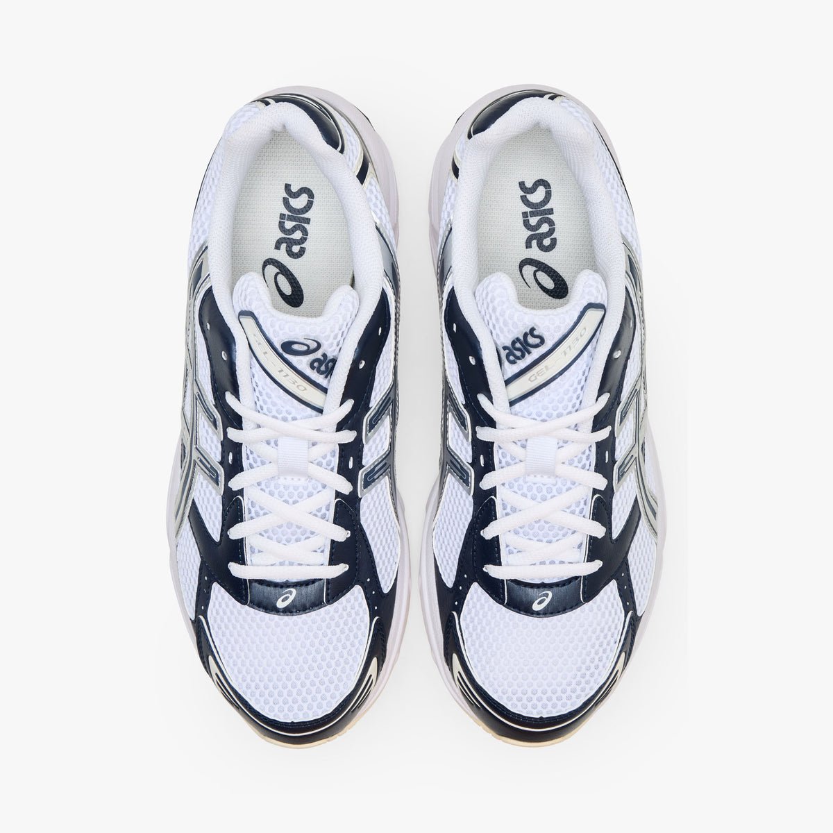 ASICS GEL-1130. Top-down overhead view of a pair of sneakers displaying white mesh toe boxes, dark midnight blue overlays, white laces, padded collars, and white branded insoles.