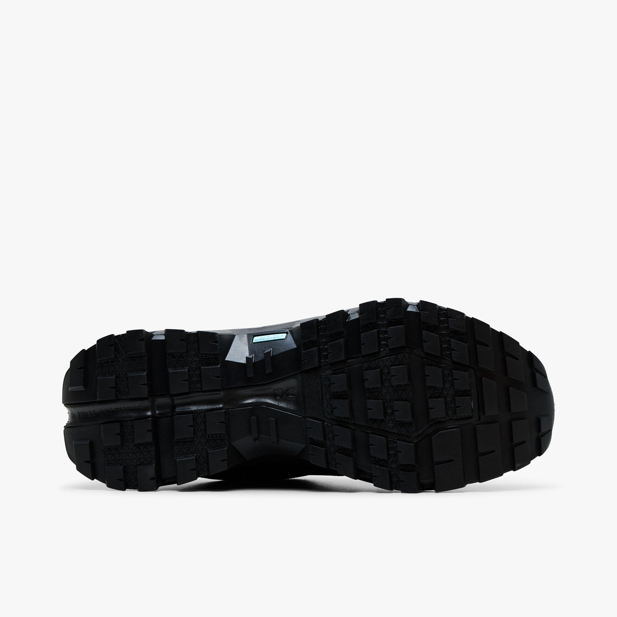 On Cloudrock Low Waterproof. Bottom view featuring all-black Missiongrip rubber outsole with deep multidirectional traction lugs and blue Speedboard accent.