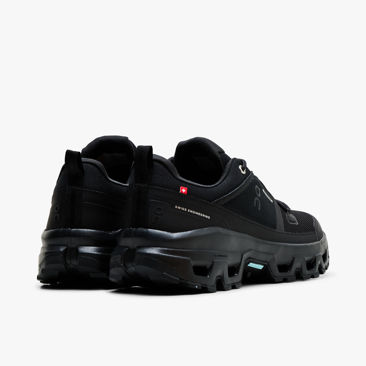 On Cloudrock Low Waterproof. Back view displaying black padded heel collars, red Swiss flag accent, heel pull loops, and thick CloudTec trail cushioning.