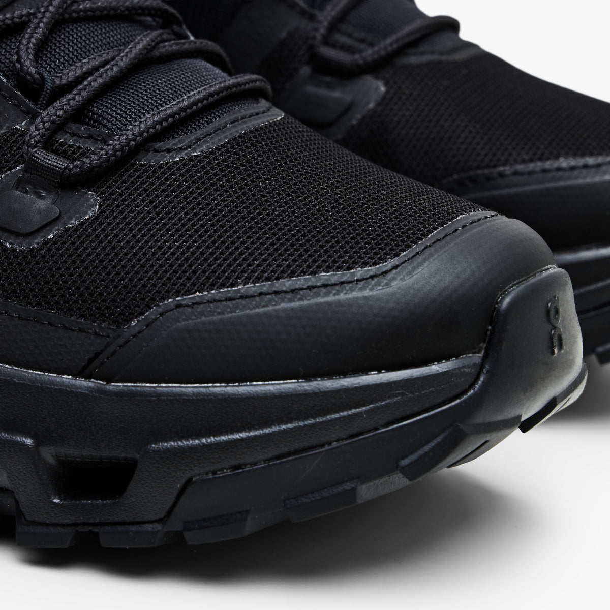 On Cloudrock Low Waterproof. Close-up view highlighting reinforced rubber toe cap, breathable black mesh upper, and protective mudguard overlay.