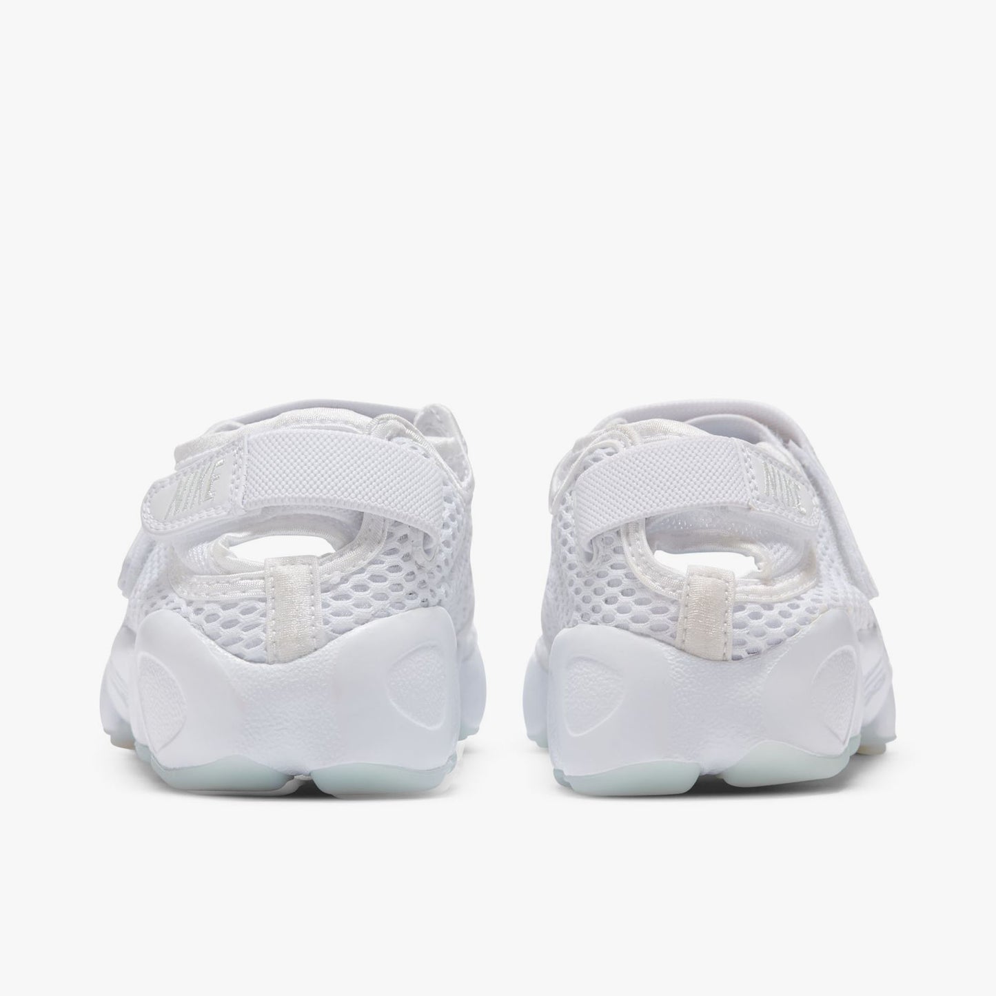 Nike Women's Air Rift Breathe. Rear view of white split-toe sneakers with adjustable heel straps, mesh panels and rounded soles.