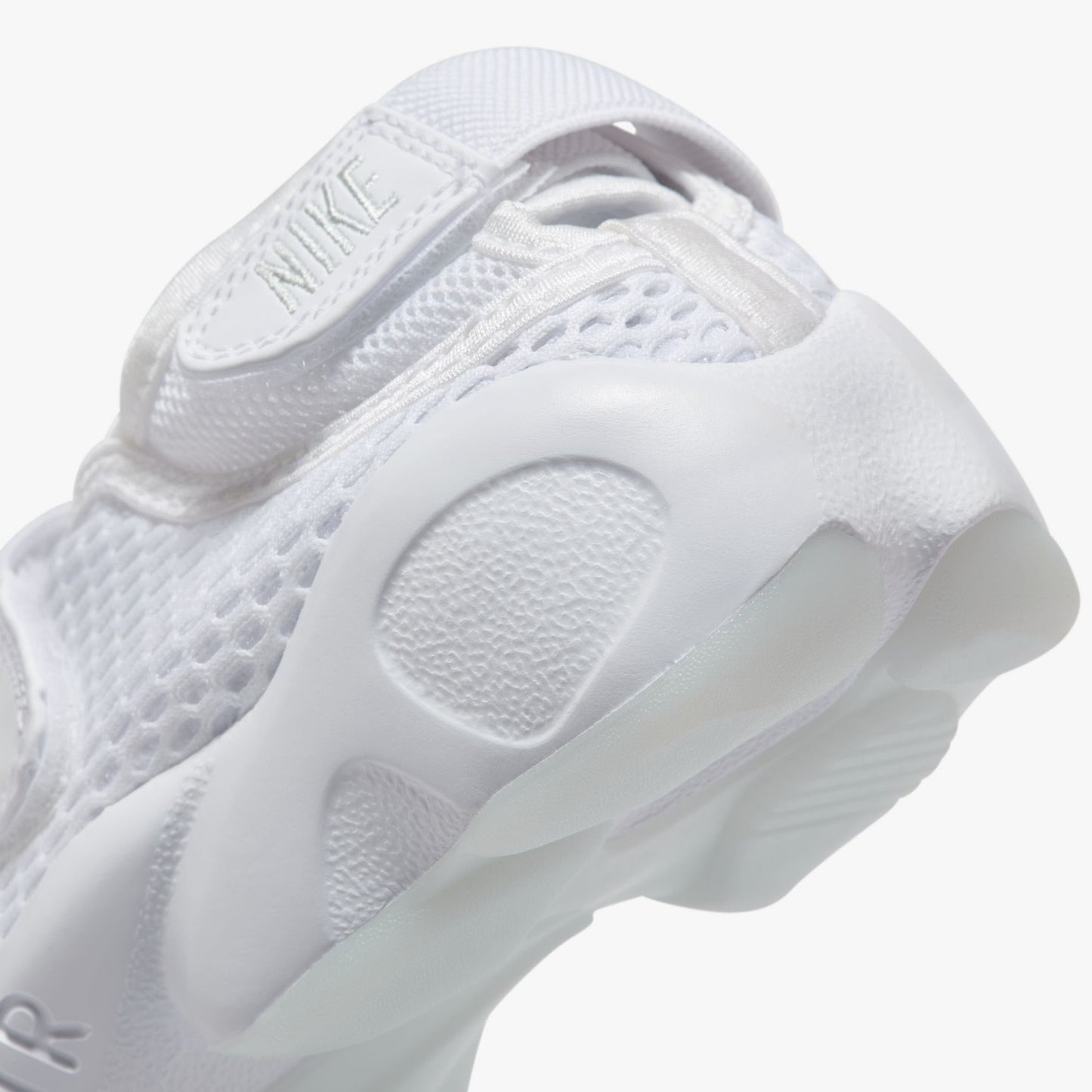 Nike Women's Air Rift Breathe. Close-up of white split-toe sneaker showing adjustable heel strap, rounded side panels and sculpted sole.