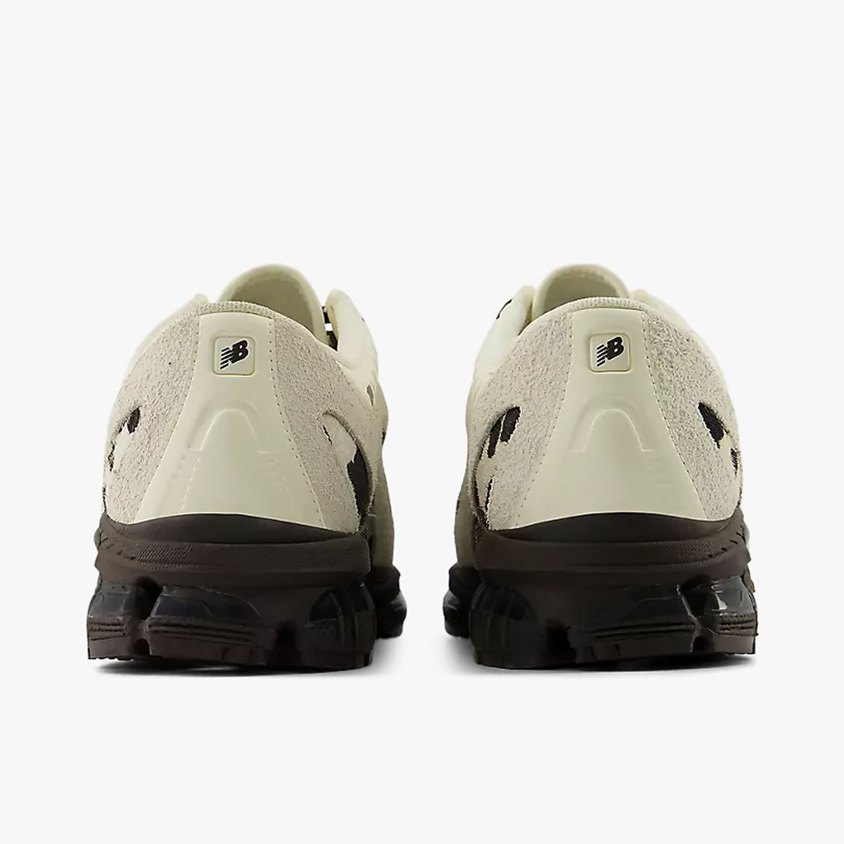 New Balance 1890A Moc-Toe. Rear view of a pair of hybrid shoes displaying angora suede heel counters, small dark NB logo badges, and rich earth brown segmented cushioned midsoles.