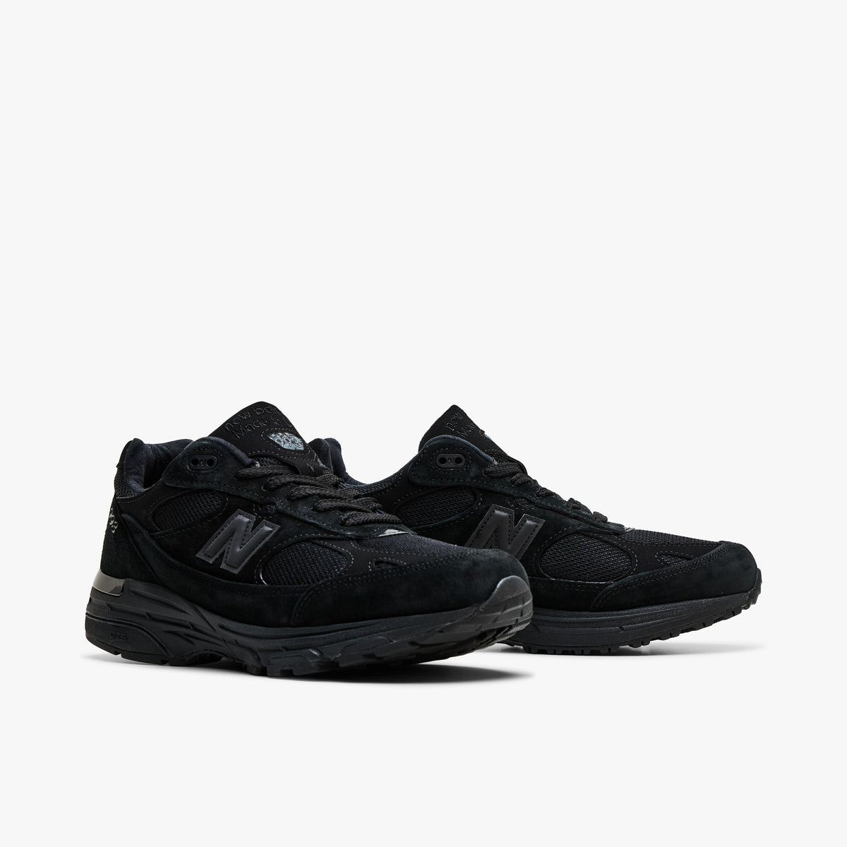 New Balance Made In USA 993. Three-quarter view of pair showcasing rich black suede overlays, breathable mesh base, matching black laces, and thick rubber soles.