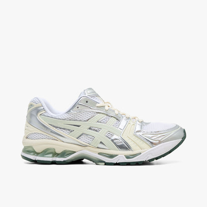 ASICS GEL-KAYANO 14. Side view of technical retro running sneakers featuring a white open mesh upper, metallic silver and light sage synthetic overlays, light sage Tiger Stripes, GEL-KAYANO 14 text branding on the lateral heel, white foam midsole with visible green GEL cushioning units, and a dark sage green rubber outsole. 
