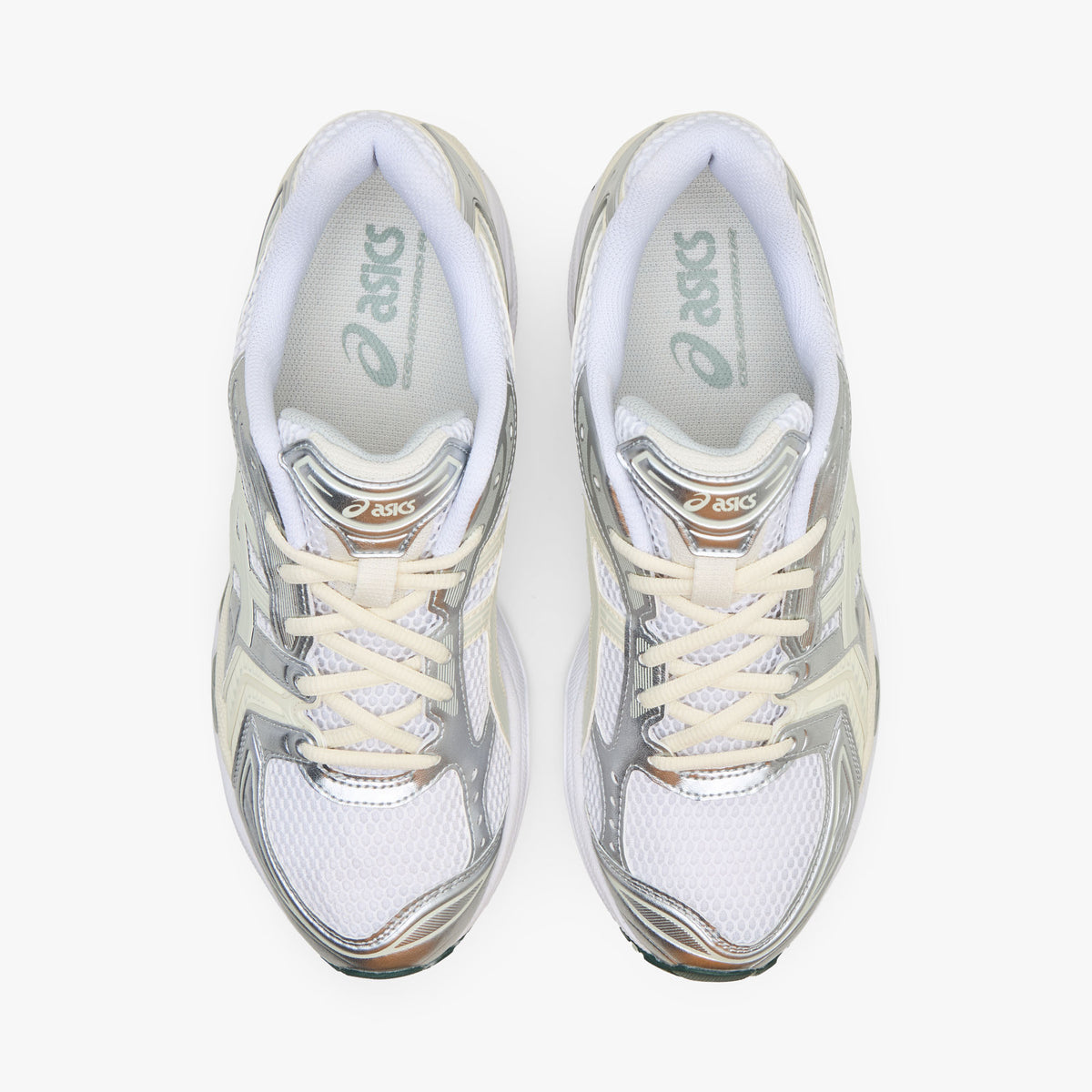 ASICS GEL-KAYANO 14. Top-down overhead view of a pair of sneakers displaying white mesh toe boxes, metallic silver and light sage overlays, cream laces, padded collars, and white branded insoles with sage logo accents. 