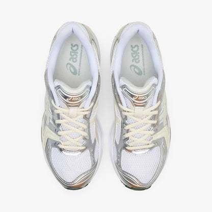 ASICS GEL-KAYANO 14. Top-down overhead view of a pair of sneakers displaying white mesh toe boxes, metallic silver and light sage overlays, cream laces, padded collars, and white branded insoles with sage logo accents. 