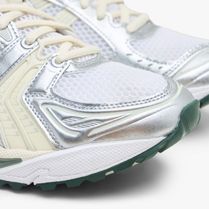ASICS GEL-KAYANO 14. Close-up view of the forefoot showing a white mesh toe box, metallic silver and light sage synthetic overlays, white midsole, and dark sage green outsole tip. 