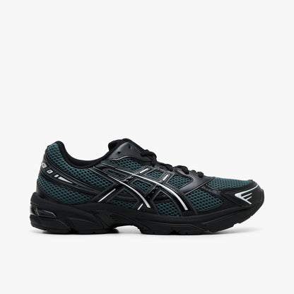 ASICS GEL-1130. Side view of tech sneakers featuring a dusty fern green mesh upper, black synthetic overlays, silver metallic Tiger Stripes with silver piping, black foam midsole with GEL technology cushioning in the heel, and black rubber outsole. 
