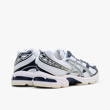 ASICS GEL-1130. Rear three-quarter view showing white mesh heel collars, dark midnight blue synthetic heel overlays with silver accents, and off-white GEL-cushioned midsoles. 