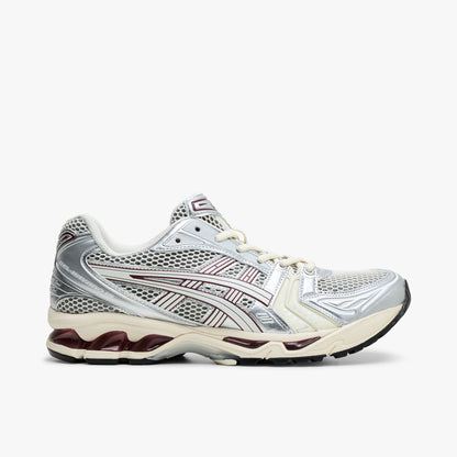 ASICS GEL-KAYANO 14. Side view of Ivory and metallic silver running shoes with burgundy accents and GEL cushioned midsole. 