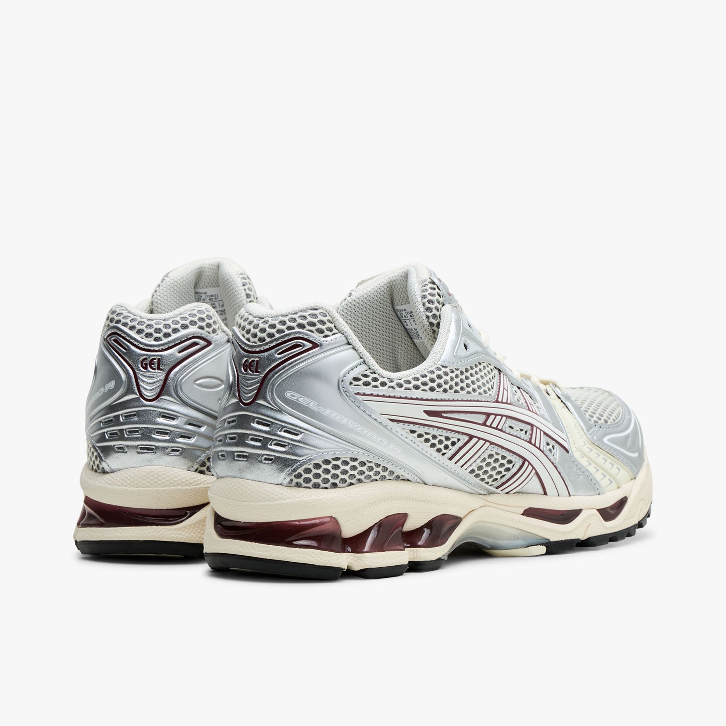 ASICS GEL-KAYANO 14. Rear view of silver and Cream running shoes showing metallic heel overlays and dark red GEL cushioning inserts. 