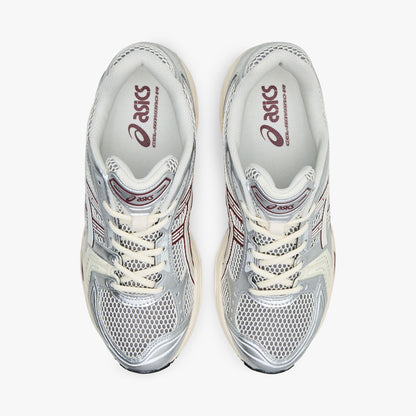 ASICS GEL-KAYANO 14. Top view of pair of silver running shoes showing cream mesh toe box, textile lining, cream laces, and padded collar. 