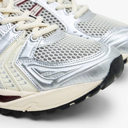 ASICS GEL-KAYANO 14. Close-up of metallic silver synthetic overlays, open mesh toe box, and cream rubber midsole tip. 
