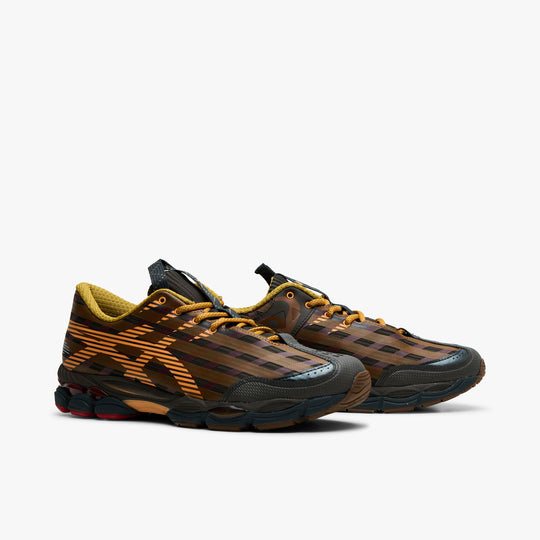 Asics US8-S GEL-SJ33. Three-quarter view of black coffee and orange lily sneakers with orange laces, striped uppers and layered soles.