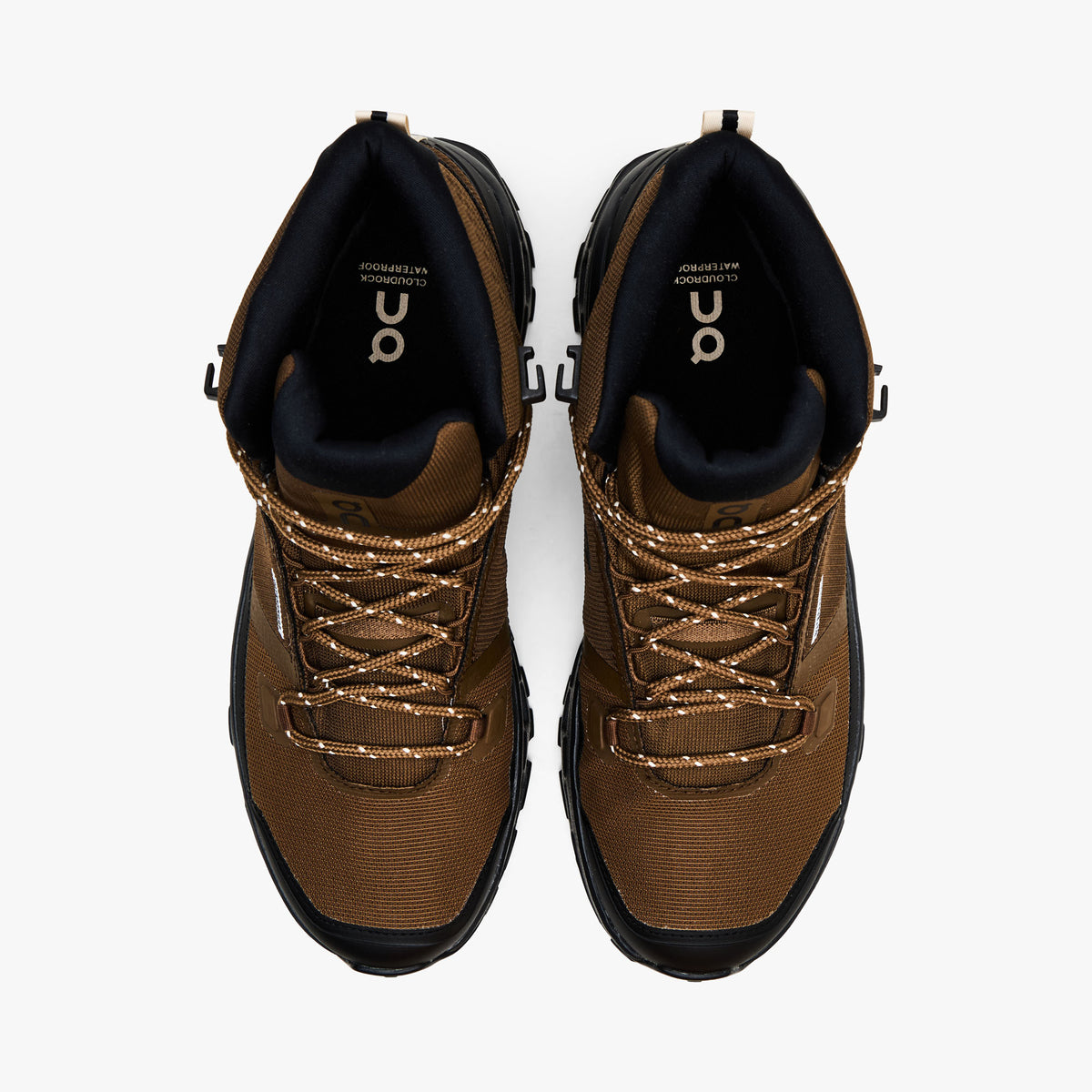 On Cloudrock Mid Waterproof. Top-down view showcasing earth brown waterproof toe boxes, speckled trail laces, black collar lining, and branded insoles. 