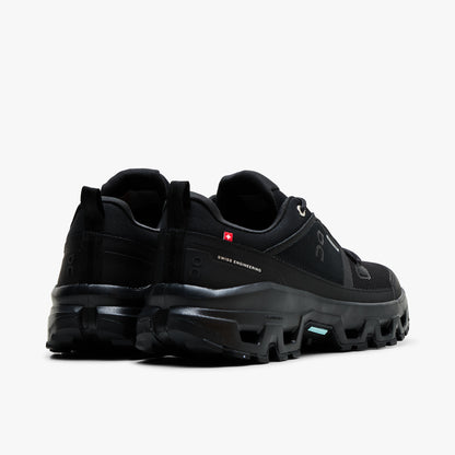 On Cloudrock Low Waterproof. Back view displaying black padded heel collars, red Swiss flag accent, heel pull loops, and thick CloudTec trail cushioning.