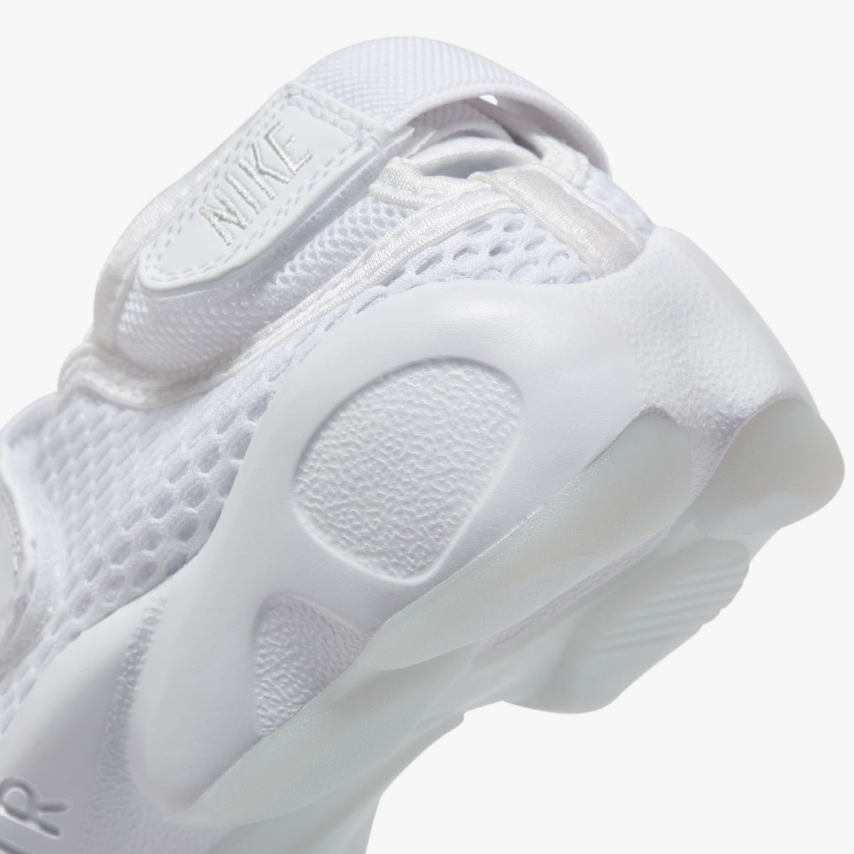 Nike Women's Air Rift Breathe. Close-up of white split-toe sneaker showing adjustable heel strap, rounded side panels and sculpted sole.