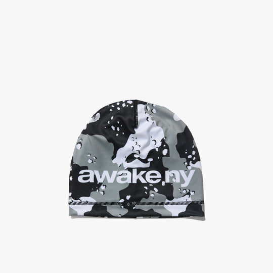 Awake NY Camo Crown Skully. Front view of a skullcap beanie featuring an all-over black, grey, and white desert camouflage pattern with white "awake ny" logo print across the front band. 