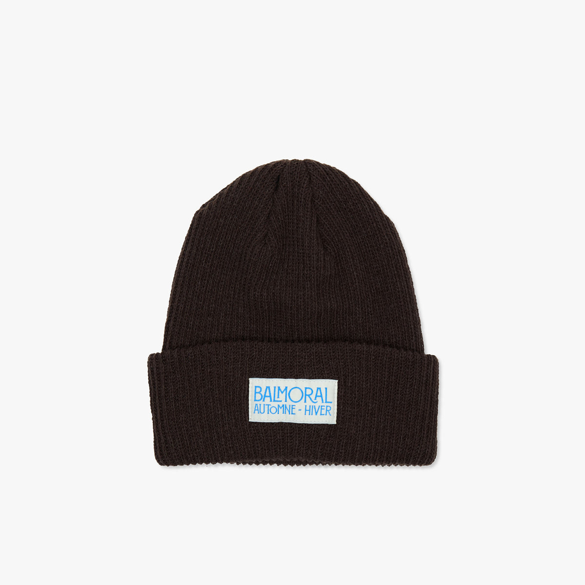 Balmoral Orchard Cotton Beanie. Front view of a dark coffee brown ribbed knit cotton beanie featuring a folded cuff and a white woven brand patch with bright blue "BALMORAL AUTOMNE - HIVER" text centered on the cuff. 