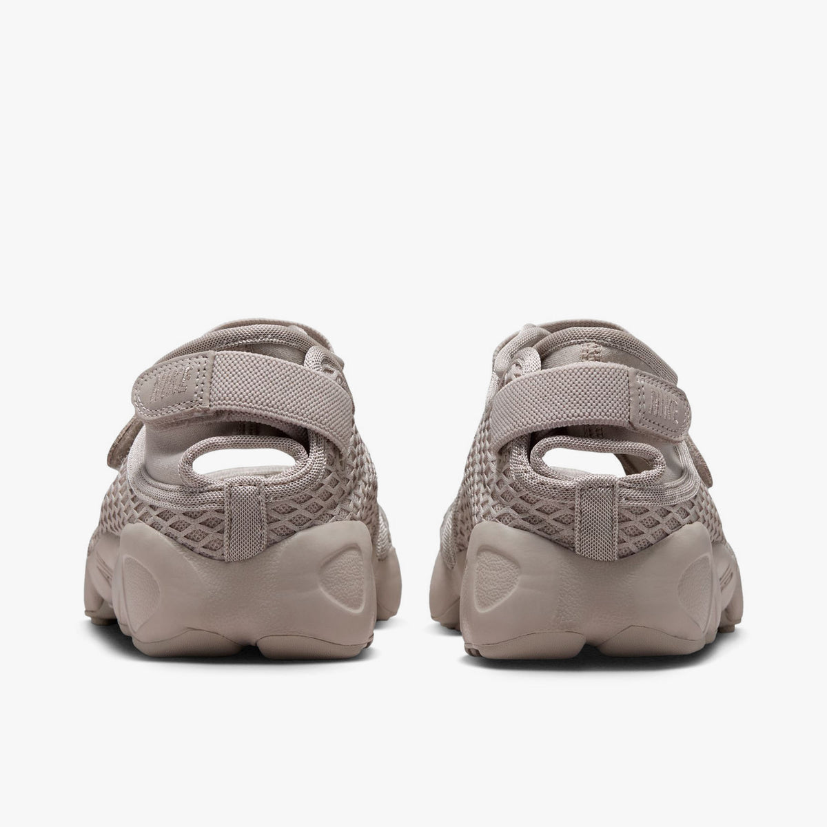 Nike Women's Air Rift. Rear view of Cream II split-toe shoes showing adjustable hook-and-loop heel straps and sculpted midsoles. 
