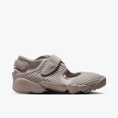 Nike Women's Air Rift. Side view of Cream II split-toe shoes with textured mesh upper, midfoot strap, and chunky foam midsole with AIR debossing. 
