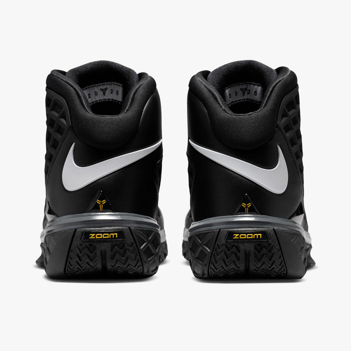 Nike Kobe III Protro. Rear view of pair of high-top basketball shoes showing wrapped white Swoosh logos across the black heel counters, gold Kobe signatures, and dark textured midsoles. 