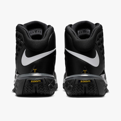 Nike Kobe III Protro. Rear view of pair of high-top basketball shoes showing wrapped white Swoosh logos across the black heel counters, gold Kobe signatures, and dark textured midsoles. 