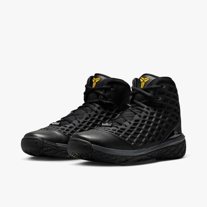 Nike Kobe III Protro. Three-quarter view of pair of high-top basketball shoes showing black diamond mesh net uppers, gold Kobe Sheath logos on the tongues, and dark anthracite cushioned midsoles. 