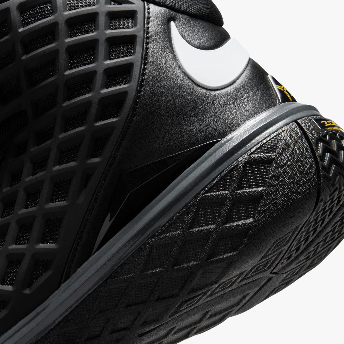 Nike Kobe III Protro. Close-up rear view of the ankle collar showing padded black lining, white Swoosh logo wrap, and interior tongue tag featuring Kobe graphics. 