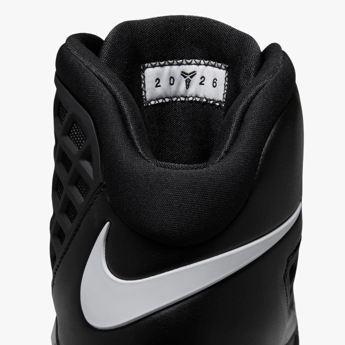 Nike Kobe III Protro. Close-up rear view of the ankle collar showing padded black lining, white Swoosh logo wrap, and interior tongue tag featuring Kobe graphics. 