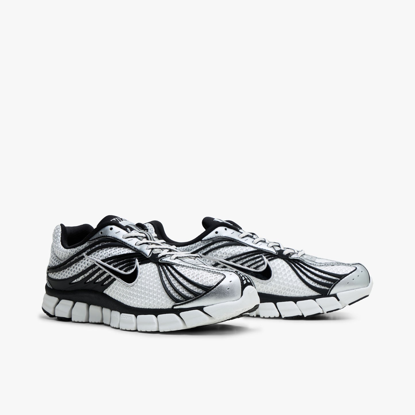 Nike Zoom Skylon 11. Three-quarter view of Summit White and Black mesh running shoes showing curved side cage design and lace closure. 