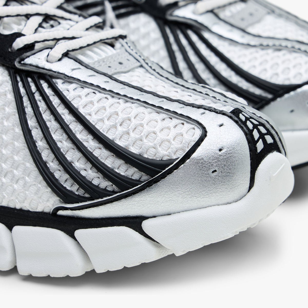 Nike Zoom Skylon 11. Close-up of perforated metallic silver toe cap, breathable Summit White mesh upper, and black linear overlay accents. 