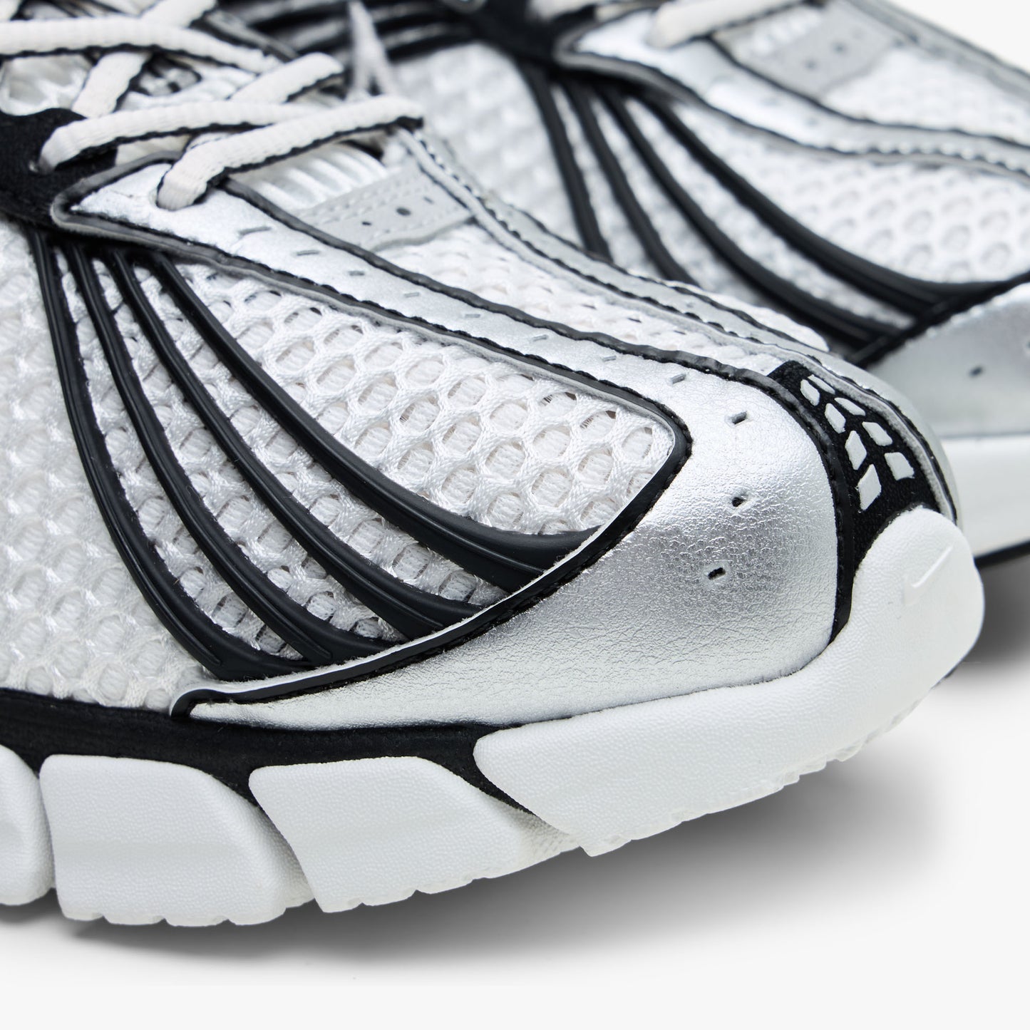 Nike Zoom Skylon 11. Close-up of perforated metallic silver toe cap, breathable Summit White mesh upper, and black linear overlay accents. 