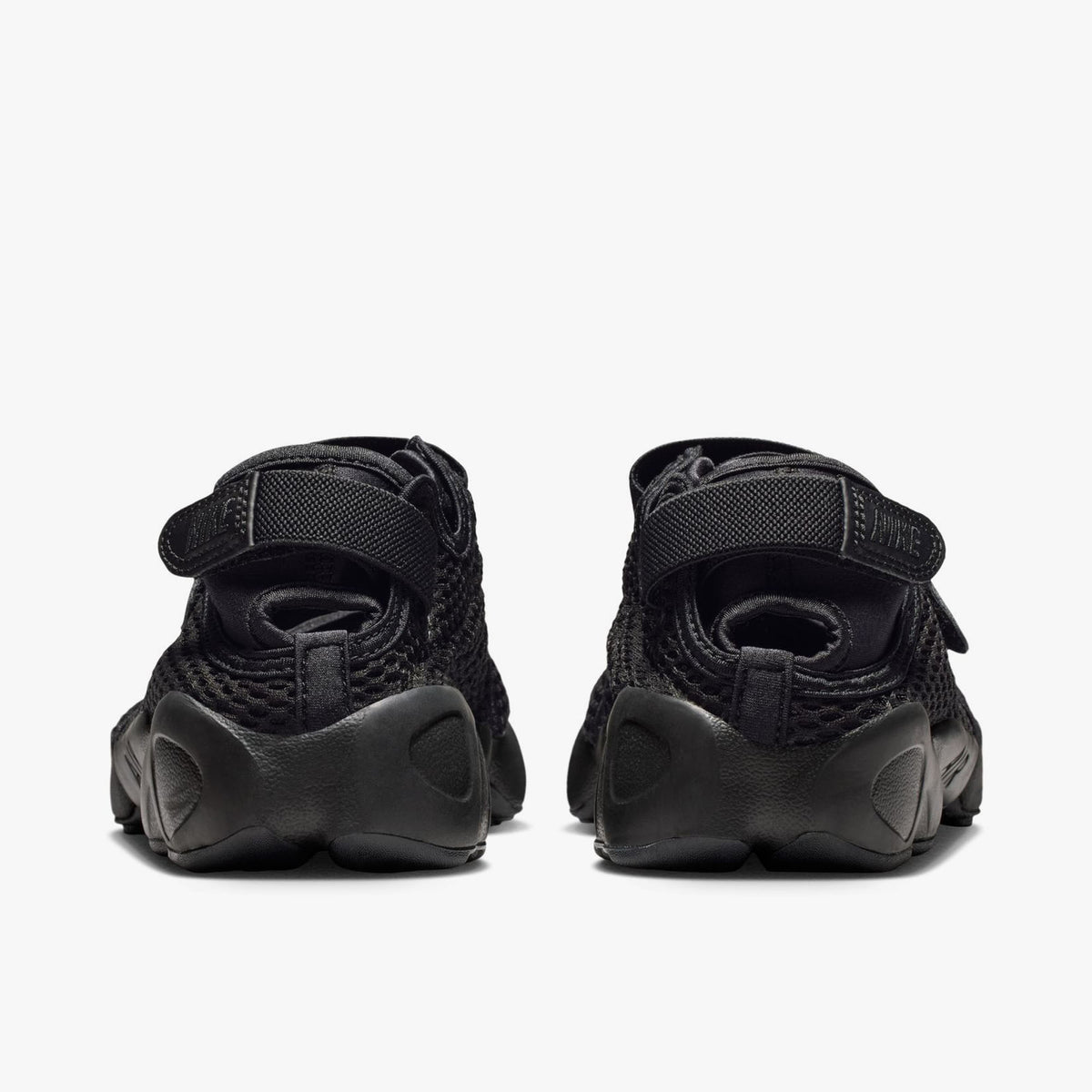 Nike Women's Air Rift Mesh. Rear view of black split-toe shoes showing adjustable heel strap closures with embroidered Nike logo hits and thick rubber midsoles. 