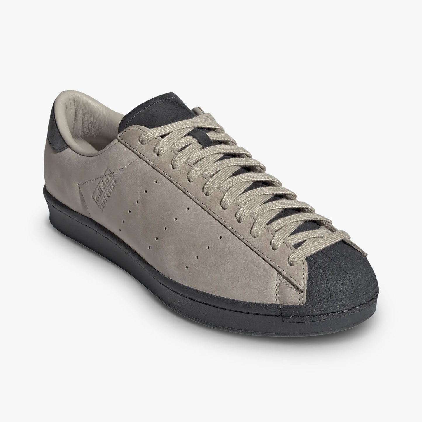 adidas Superstar Vintage Short Shell. Three-quarter view of Wonder Beige leather sneakers showing Carbon shell toe and matching beige laces. 
