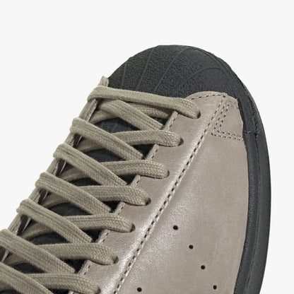 adidas Superstar Vintage Short Shell. Close-up of Carbon rubber short shell toe, beige laces, and perforated side ventilation details. 