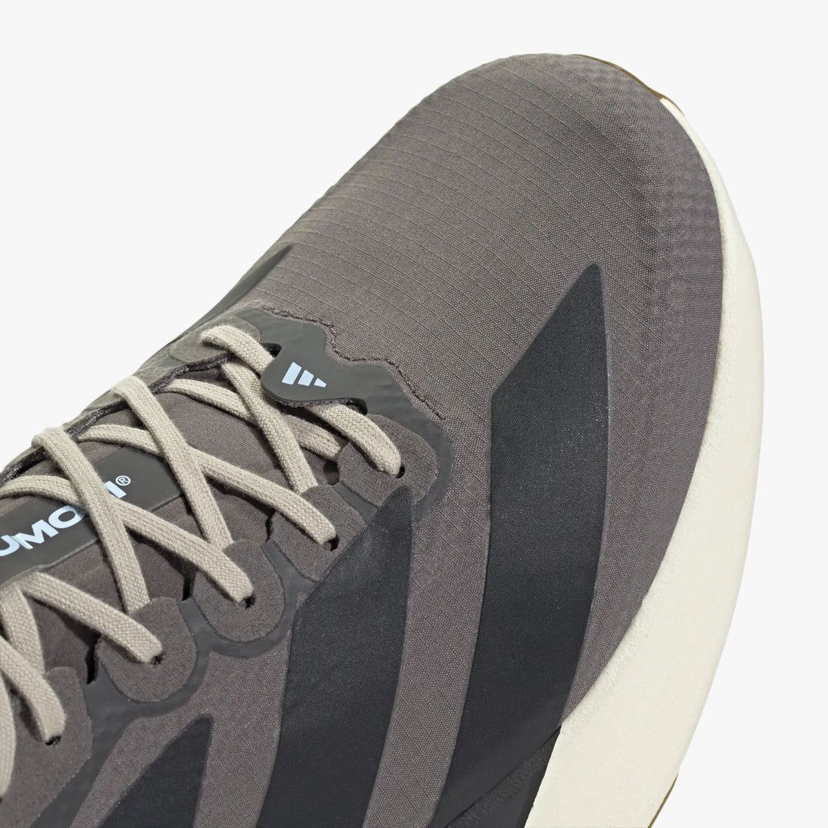adidas adizero EVO SL. Close-up of Charcoal woven upper showing light grey laces, light blue accent loop, and dark three-stripes. 