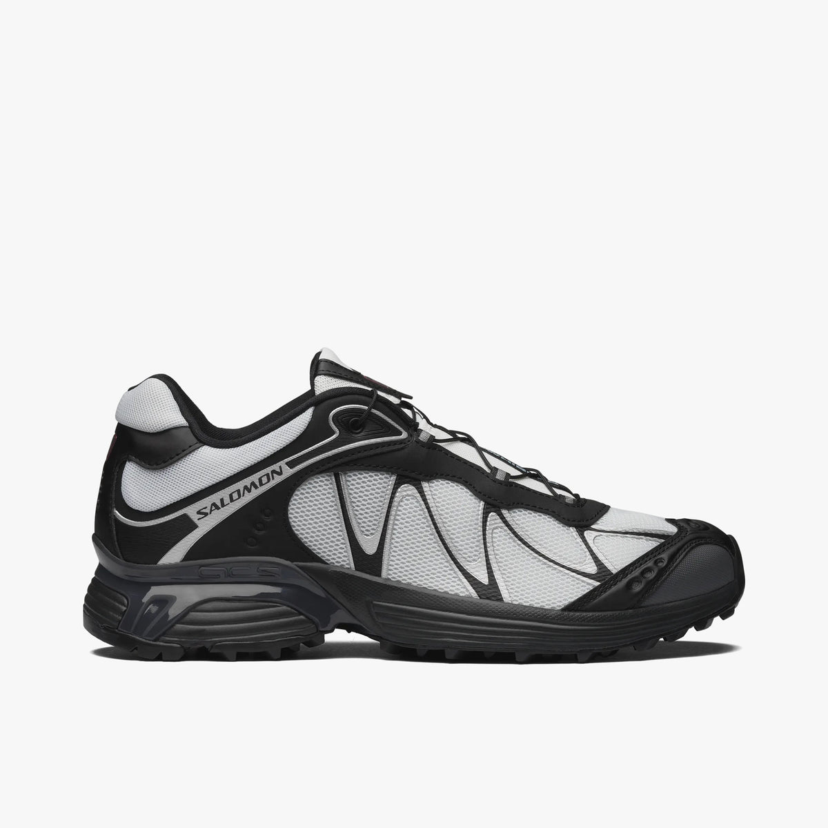 Salomon XT-WHISPER. Side view of trail-inspired lifestyle sneakers featuring a light white textile upper, dark black TPU Sensifit overlays, white overlay piping, white Salomon branding along the rear quarter overlay, black protective toe cap, black EVA midsole with Agile Chassis System stabilization, and a black lugged rubber outsole. 