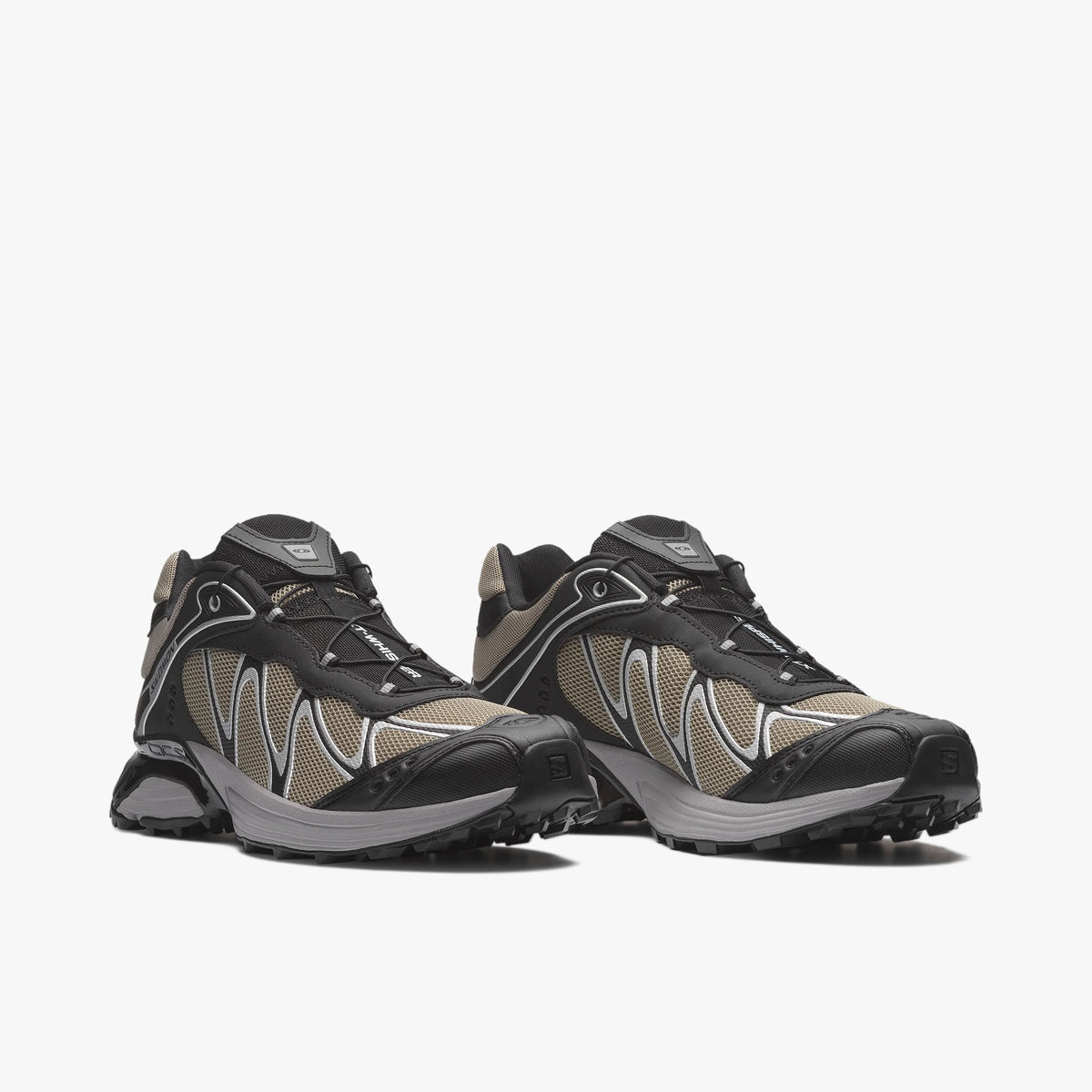 Salomon XT-WHISPER. Three-quarter view of a pair of trail running sneakers displaying silver sage mesh uppers, black TPU overlays, Quicklace speed lacing system, and dual-density cushioned midsoles. 