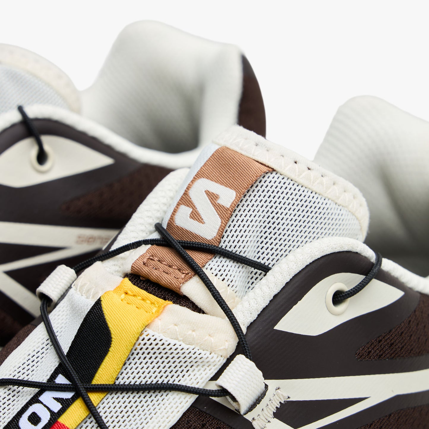 Salomon XT-6 GTX. Close-up of Quicklace lacing toggle, mesh tongue, lace shroud, and signature colorful branded tongue strip. 
