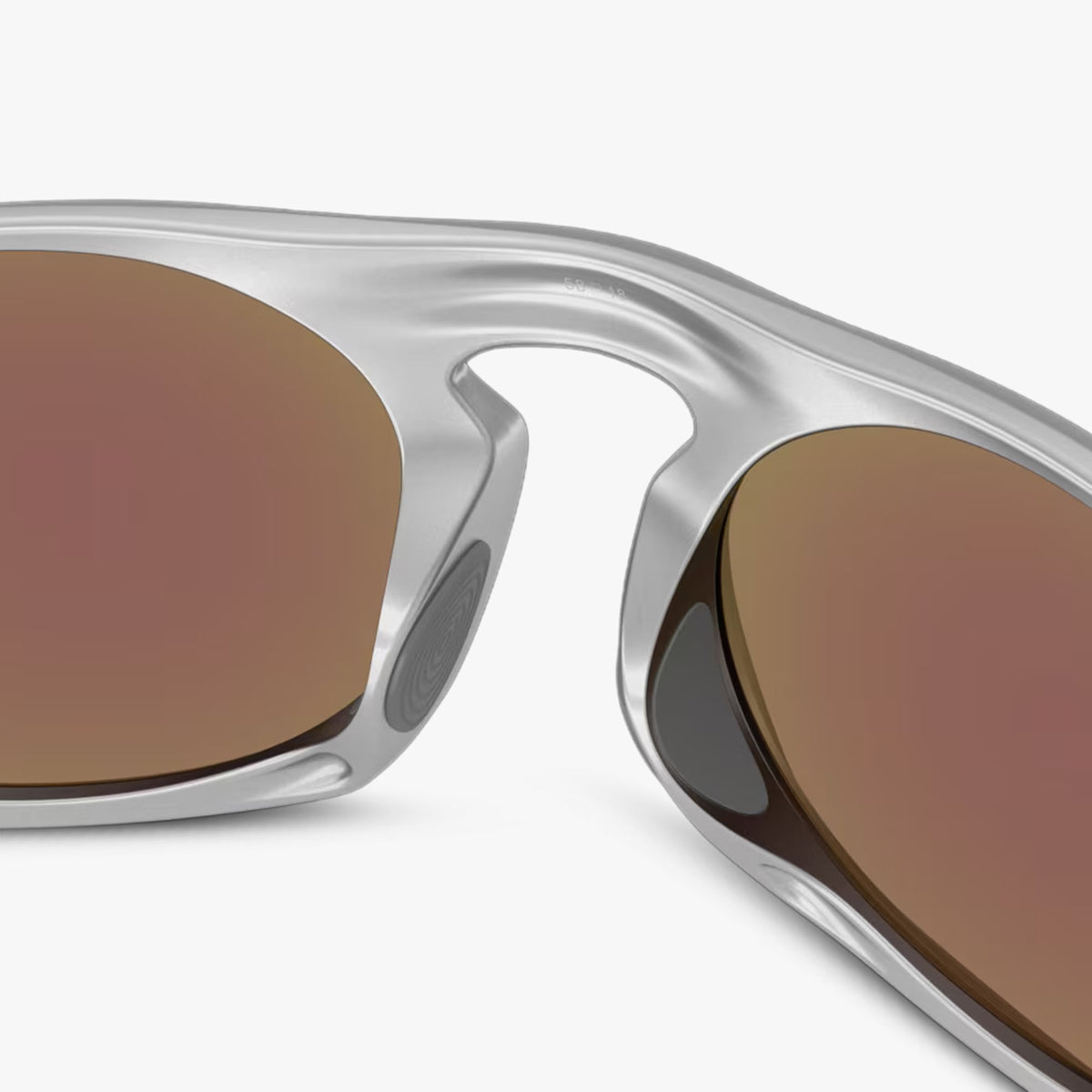 Oakley Neo Jacket. Close-up of the keyhole unobtanium nosepads and satin chrome frame on prizm sapphire tinted sunglasses. 