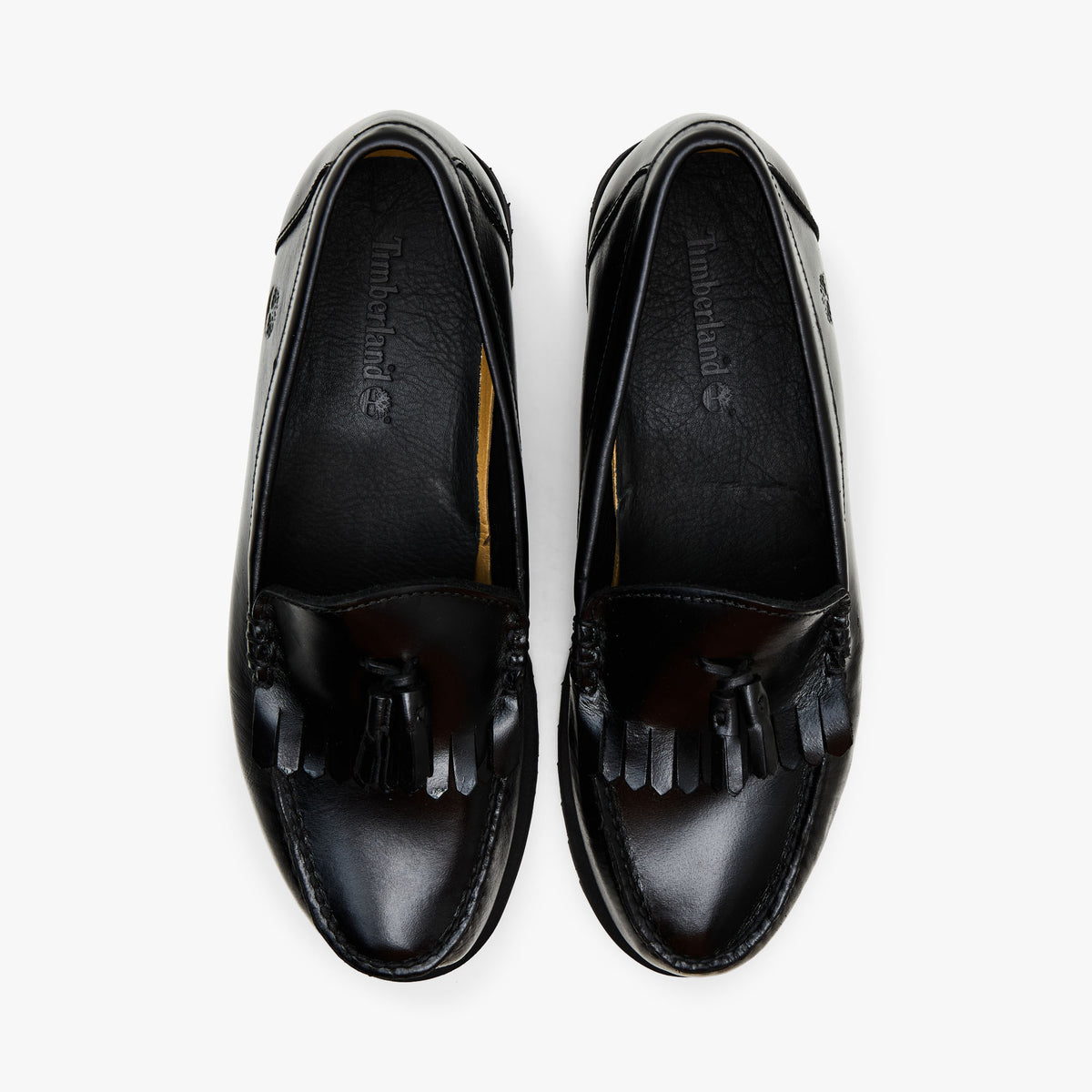 Timberland Authentic Loafer. Top-down view showcasing slip-on silhouette, kiltie fringe across the vamp, leather collars, and dark branded insoles. 
