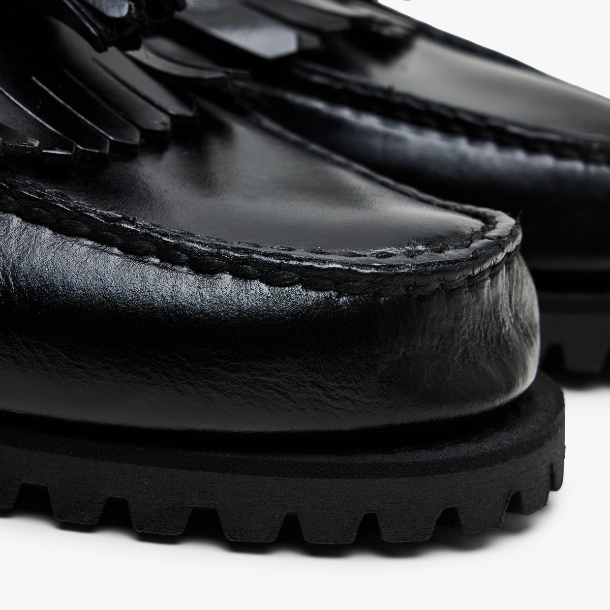Timberland Authentic Loafer. Close-up view of toe box displaying hand-sewn moc-toe stitch detailing, kiltie fringe overlay, and stacked rubber lug sole. 