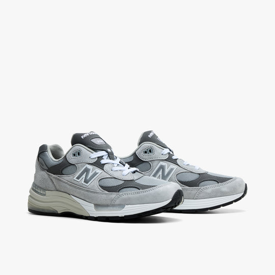 New Balance Made in USA 992. Three-quarter view of grey suede sneakers showing layered mesh panels and lace-up closure. 