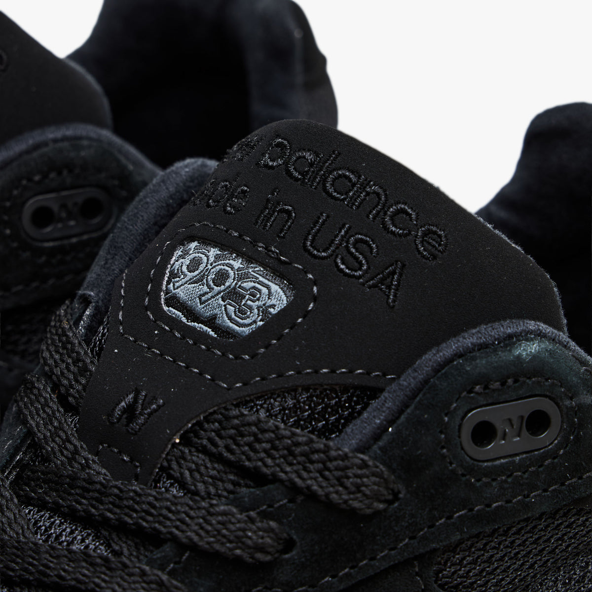 New Balance Made In USA 993. Close-up view highlighting black suede tongue with embroidered "New Balance Made in USA" branding and top eyelet layout. 
