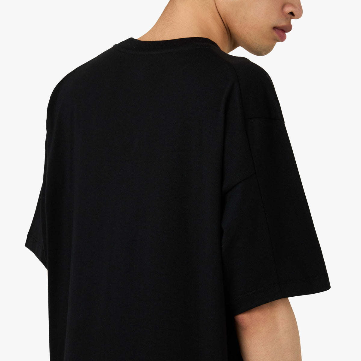 Arc'teryx Kragg SL Cotton T-Shirt. Close-up model view of the upper back and shoulder area showing smooth black organic cotton fabric construction. 