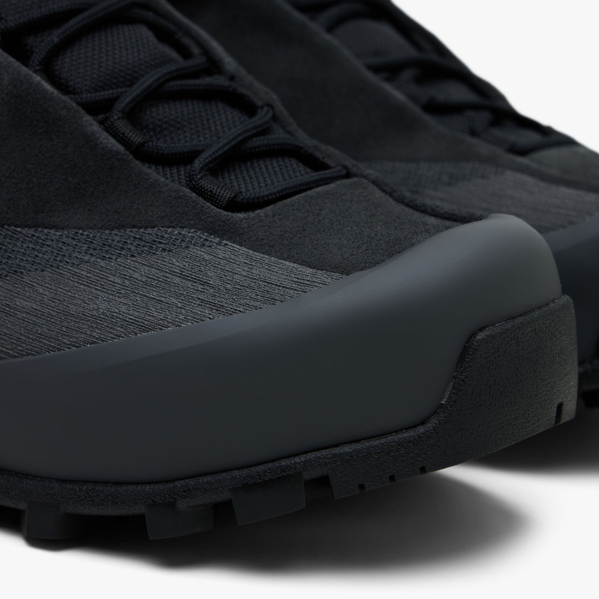 Arc'teryx Konseal Trek. Close-up view of toe box highlighting breathable dark graphite mesh vamp, reinforced protective TPU toe rand overlay, and front outsole wrapped tip. 